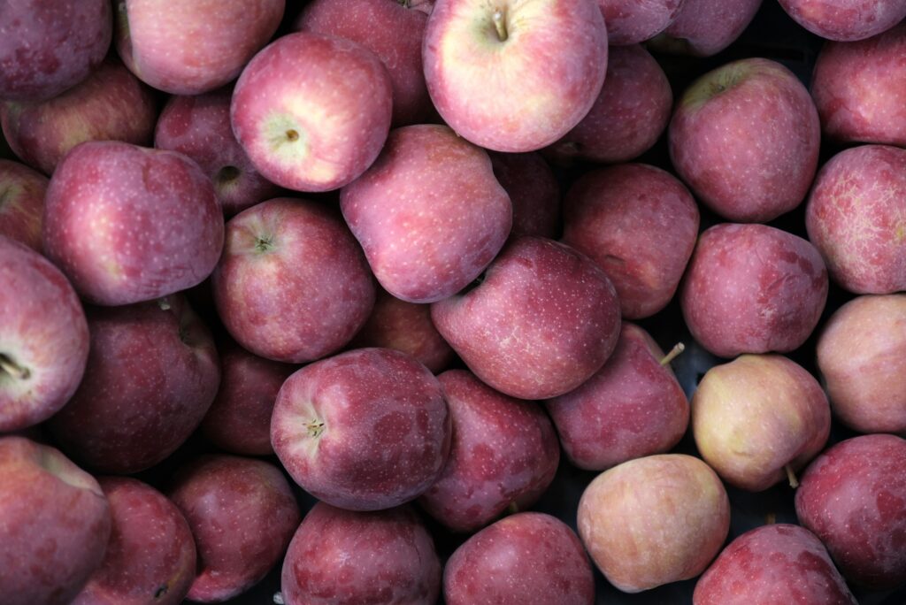 A close-up view of fresh red apples stacked at a market. Perfect for food-related content.